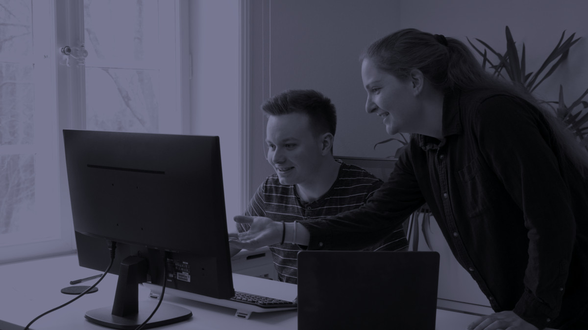 Zwei Personen diskutieren etwas vor einem Monitor.